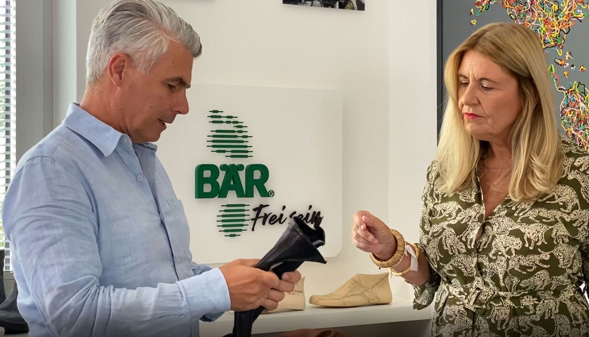 Two people examining a shoe inside a BÄR store.