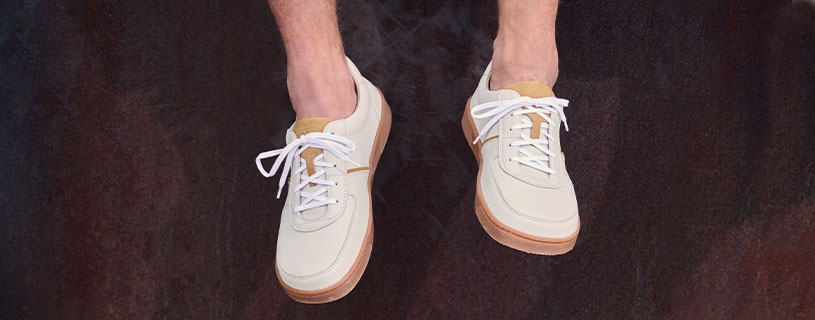 Pair of beige sneakers with white laces and brown soles