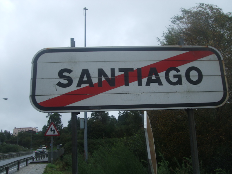 Road sign showing the end of Santiago city limits with a red diagonal line through the name.