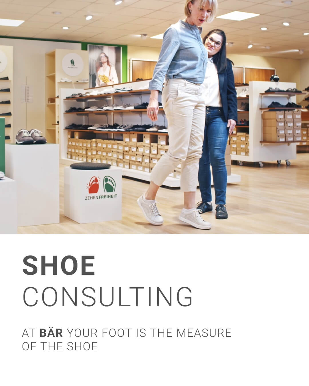 Two women discussing shoe fit in a BÄR shoe store with shoe boxes and displays in the background.